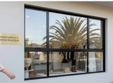 Window view of a store interior with palm tree reflection